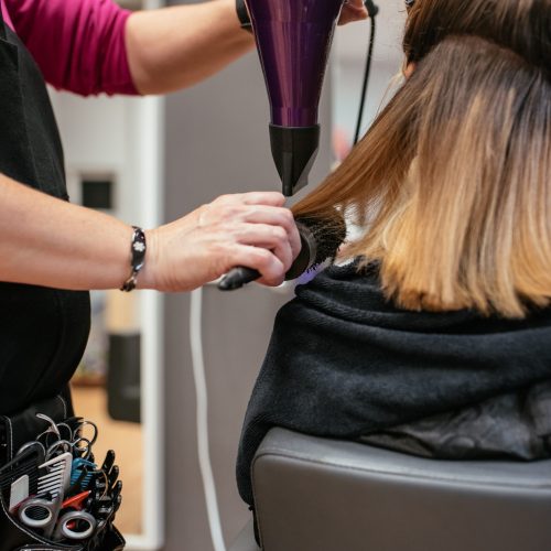 Hairdresser drying woman's hair