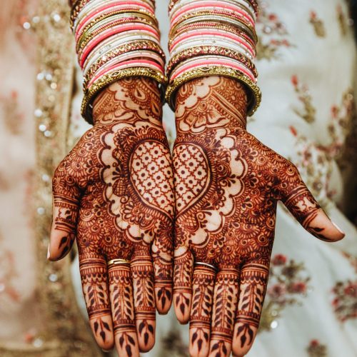 Indian wedding bangles and  mehandi henna coloured hands with 
reflective ornament