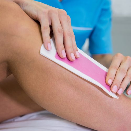 Woman getting her leg hair removed at beauty salon